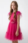 Fetiță în rochie fucsia din tul la o petrecere de botez
