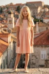 Rochie Sia roz – siluetă întreagă din față, cu orașul vechi în fundal