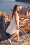 Rochie albă plisată Rozalia pe zidurile orașului – din lateral