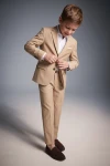 Costum elegant pentru băiat Liam bej – sacou și pantaloni, băiat care își încheie sacoul, din față