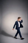Costum pentru băiat Sam bleumarin cu papion negru – băiat în mișcare, sacou descheiat, siluetă întreagă