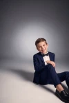 Costum pentru băiat Sam bleumarin cu papion negru – băiat așezat pe podea, din față