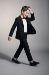 Costum elegant pentru băiat Sam negru, cu sacou, pantaloni și papion – băiat în mișcare, sacou descheiat, siluetă întreagă